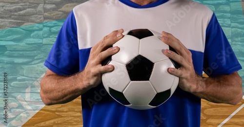 Composition of midsection of caucasian male football player holding ball © vectorfusionart