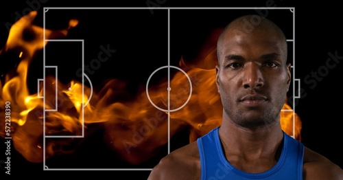 Composition of mixed race basketball player over basketball court with flames on black background