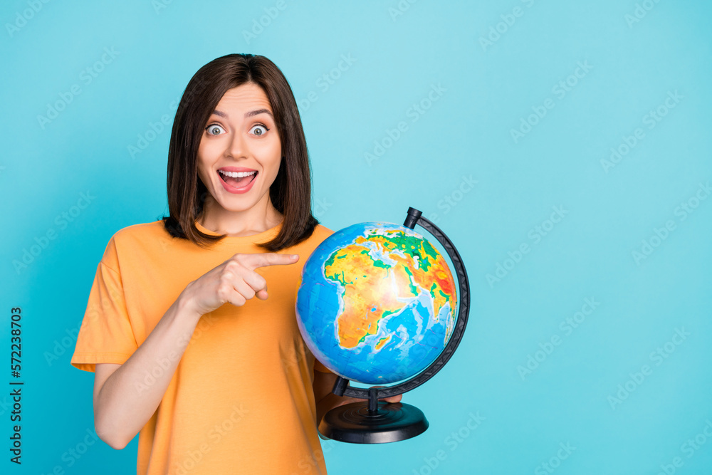 Photo of astonished lady wear stylish clothes hand direct map choose country start trip empty space isolated on blue color background Photo of astonished lady wear stylish clothes hand direct map choose country start trip empty space isolated on blue color background