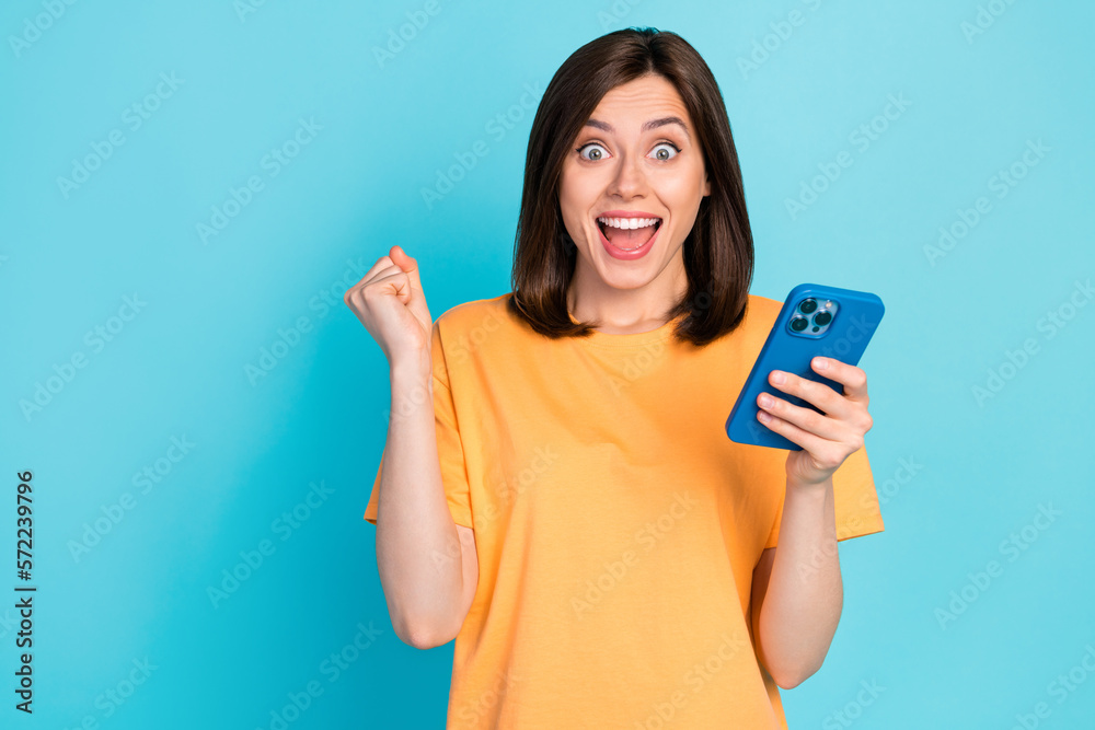 Portrait of overjoyed delighted girl raise fist celebrate follow twitter telegram tiktok isolated on blue color background Portrait of overjoyed delighted girl raise fist celebrate follow twitter telegram tiktok isolated on blue color background