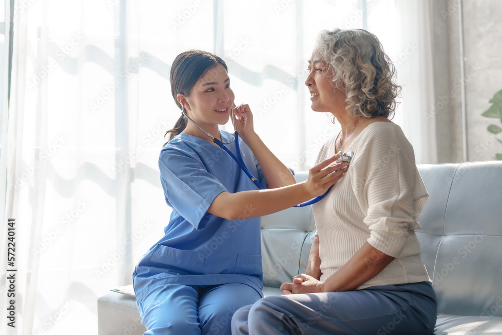 Young asian caretaker with 60s asia elderly woman consulting and encourage, take a history and recommend the right treatment, Use a stethoscope to listen to your heartbeat and check for abnormalities.