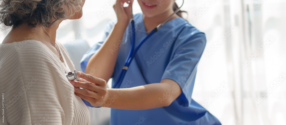 Young asian caretaker with 60s asia elderly woman consulting and encourage, take a history and recommend the right treatment, Use a stethoscope to listen to your heartbeat and check for abnormalities.