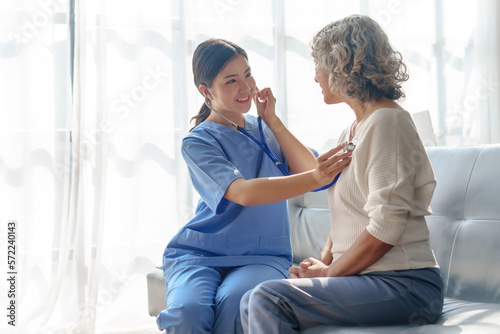 Young asian caretaker with 60s asia elderly woman consulting and encourage, take a history and recommend the right treatment, Use a stethoscope to listen to your heartbeat and check for abnormalities.