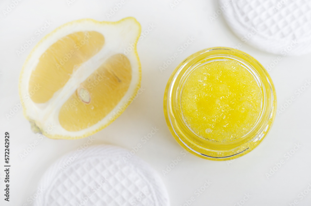 Homemade lemon sugar scrub in a small glass jar. Natural beauty treatment and spa recipe. Top view, copy space. Homemade lemon sugar scrub in a small glass jar. Natural beauty treatment and spa recipe. Top view, copy space.
