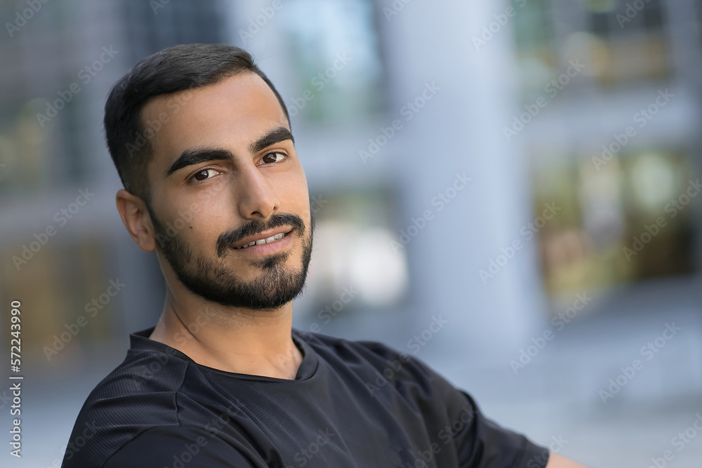 Horizontal portrait of happy handsome smiling man looking at camera on the street