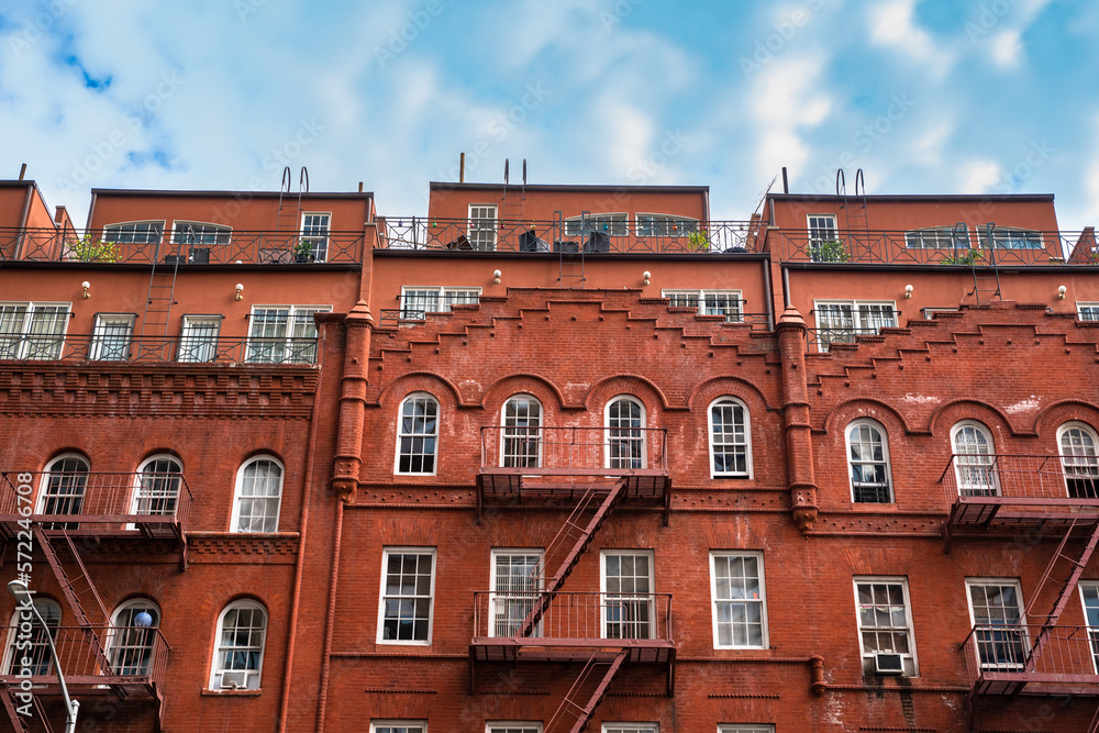 Fototapeta premium New York City brick apartment building exterior with fire escapes