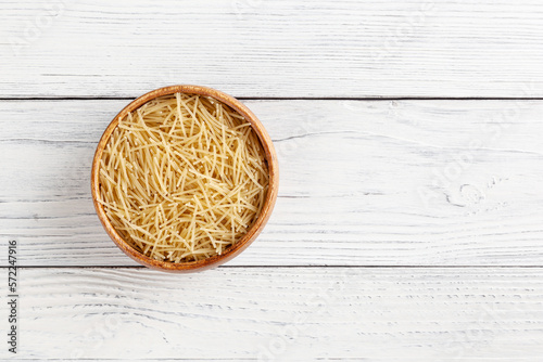 Obraz na płótnie Uncooked filini pasta in wooden bowl on white wooden background with copy space w salonie
