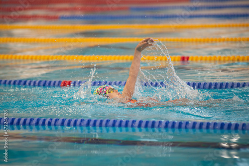 Swimmer child swims backstroke swimming style in the pool