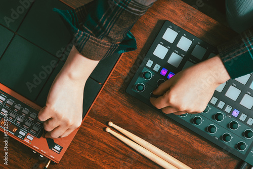 Female hands on drum pads, sequencer and drumstick photo