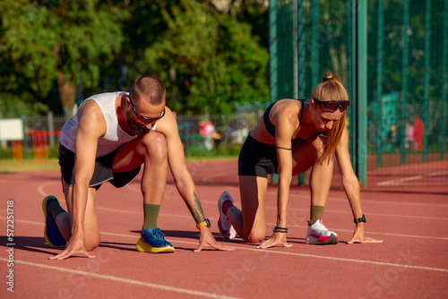 Start of the race of man and woman at the stadium, track and field athletics running, diversity joint training of men and women.