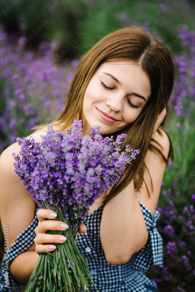 Girl sitting in a lavender flowers field. A woman walk on lavender field. Enjoy the floral glade, summer nature. Natural cosmetics concept. Female hold bouquet flowers and collect lavender. Closeup. Girl sitting in a lavender flowers field. A woman walk on lavender field. Enjoy the floral glade, summer nature. Natural cosmetics concept. Female hold bouquet flowers and collect lavender. Closeup.