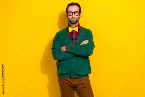 Photo portrait of young handsome man eyewear folded arms serious strict manager wear trendy green look isolated on yellow color background