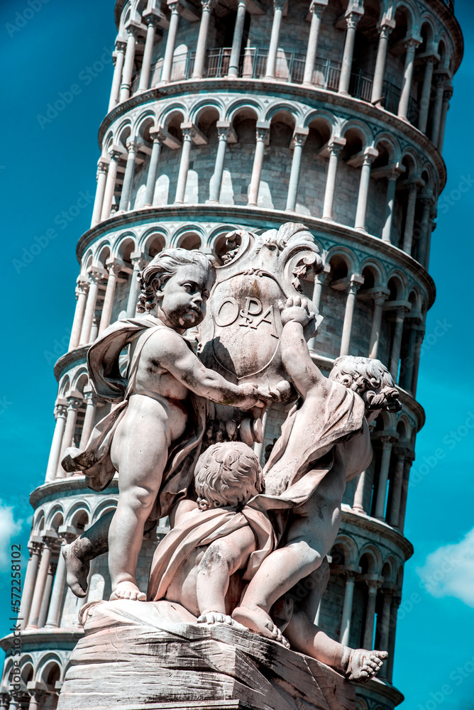 Monument on the background of the famous sloping tower with columns in Pisa, Italy. fascinating exotic amazing places.
