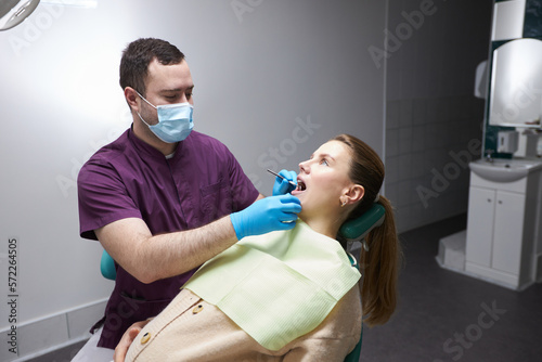 Charming pregnant woman at regular medical check-up in dentist office. Oral and dental care concept