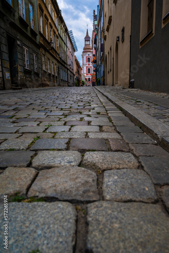 An old street made of "cat's heads" in Poznań with a view of the Basilica of Our Lady of Perpetual.