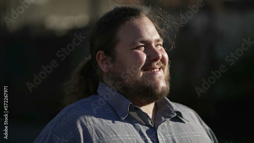 One meditative young man standing outside turning head to sky smiling with HOPE and FAITH. Male caucasian person in contemplation standing in sunlight