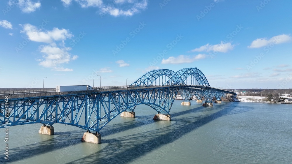 Naklejka premium Beautiful South Grand Island Bridge crossing Niagara River with cars and trucks driving under blue sky and clouds