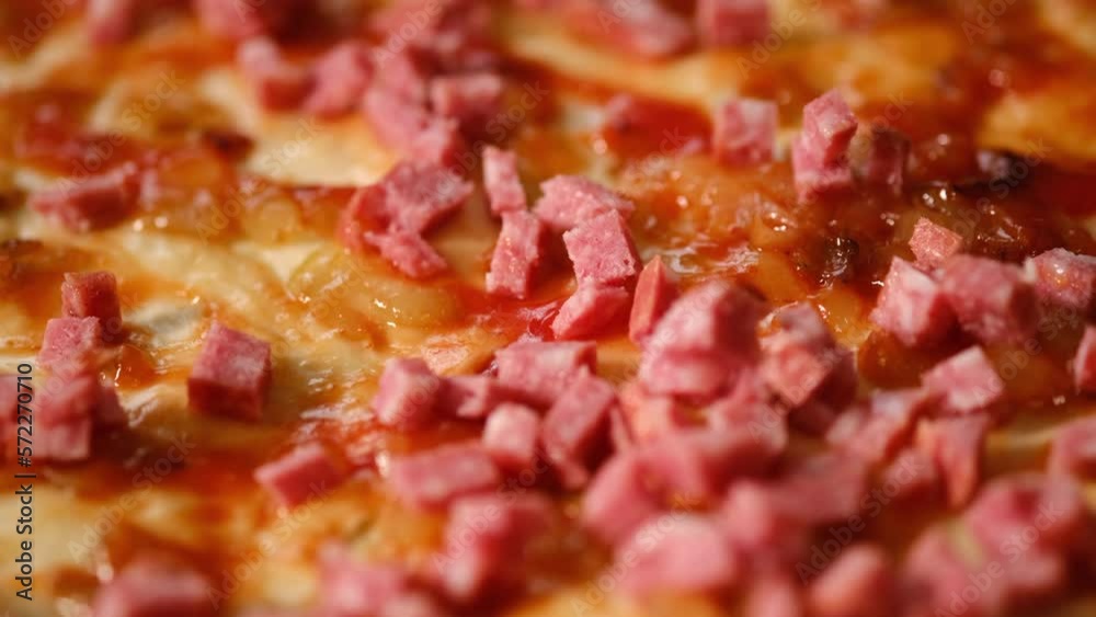 Work of cook. Close up of pizza with tomato paste, sausage. Cooking pizza at home. Pizzaiolo making pizza and food traditional concept. Selective focus Work of cook. Close up of pizza with tomato paste, sausage. Cooking pizza at home. Pizzaiolo making pizza and food traditional concept. Selective focus