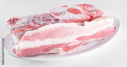 Raw meat on white plate on white background