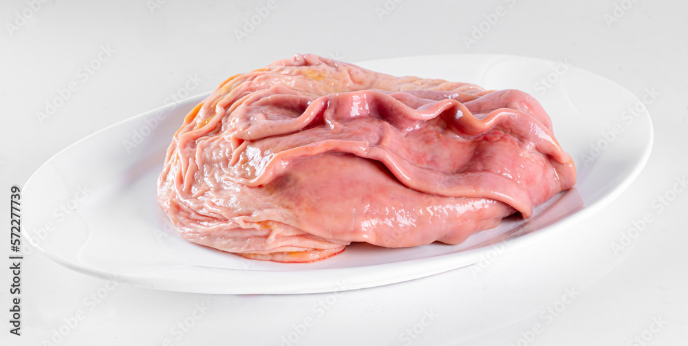 Fresh pork offal on a white plate on a white background