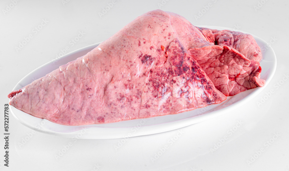 Fresh pork offal on a white plate on a white background Fresh pork offal on a white plate on a white background
