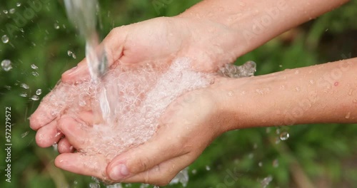 Closeup of wet female hands and clear water splashes