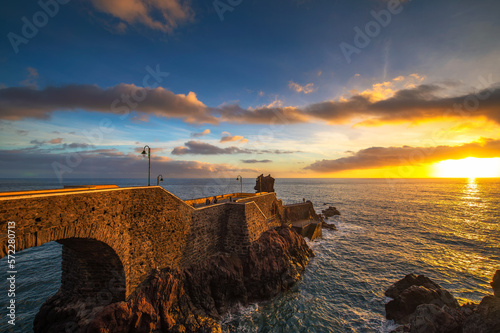 Sunset at the pier of Ponta do Sol in Madeira Island, Portugal