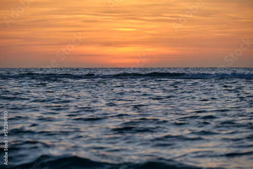 Dramatic red ocean waves at sunset with soft evening sea dark water