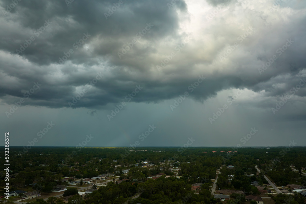 Landscape of dark ominous clouds forming on stormy sky before heavy thunderstorm over rural town area Landscape of dark ominous clouds forming on stormy sky before heavy thunderstorm over rural town area