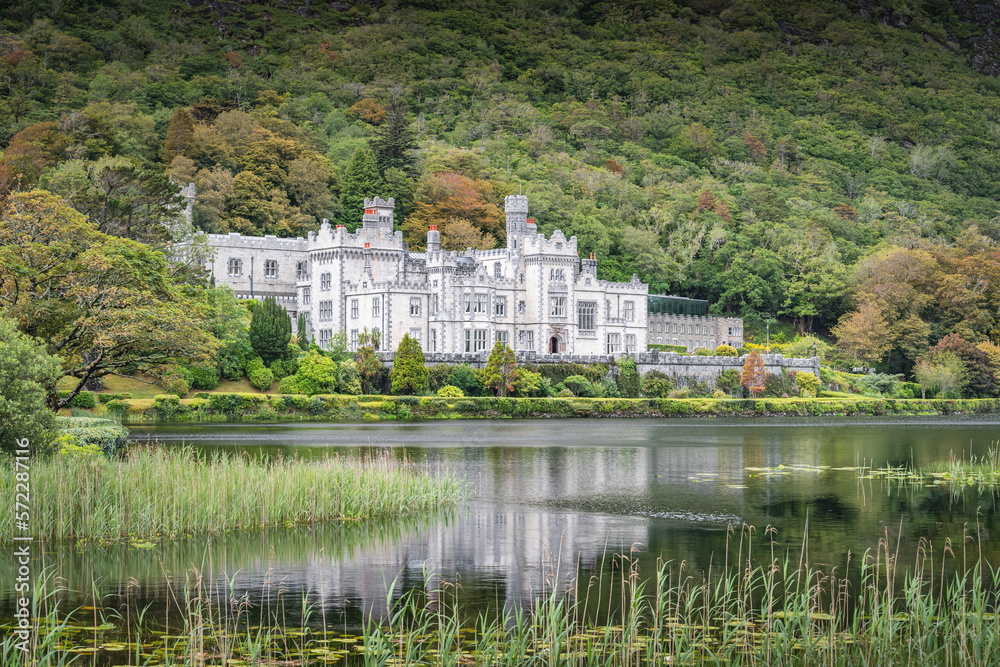 Kylemore Abbey, beautiful white castle reflected in lake at the foot of a mountain. Benedictine monastery founded in 1920, Connemara, Galway, Ireland Kylemore Abbey, beautiful white castle reflected in lake at the foot of a mountain. Benedictine monastery founded in 1920, Connemara, Galway, Ireland