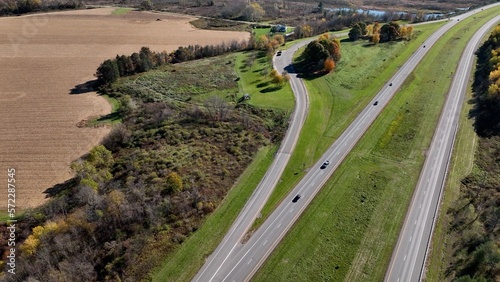 Cars traveling across American on road trip on highway roads through beautiful countryside during Autumn season with Fall colors in trees and landscape