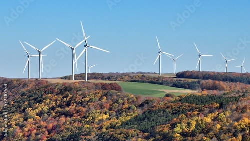 Valokuva Wind turbines on wind farm on hillside landscape generating sustainable energy e