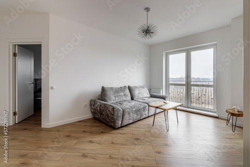 Living room with a gray sofa and a round coffee table and a huge window