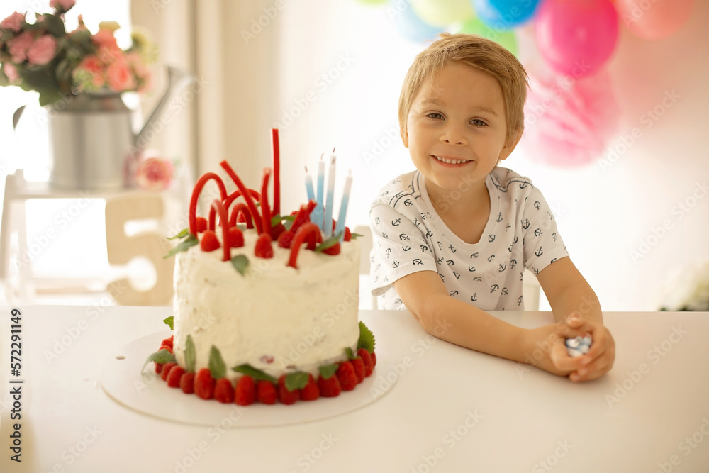 Cute child, preschool boy, celebrating birthday at home with homemade cake with raspberries, mint and candies Cute child, preschool boy, celebrating birthday at home with homemade cake with raspberries, mint and candies