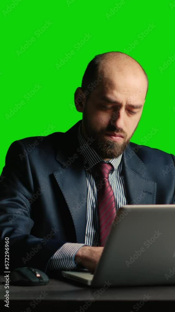 Vertical video: Businessman over greenscreen feeling tired and stressed, sitting laid back at desk. Team leader working over chroma key backdrop with isolated mockup template, exhausted adult. Vertical video: Businessman over greenscreen feeling tired and stressed, sitting laid back at desk. Team leader working over chroma key backdrop with isolated mockup template, exhausted adult.