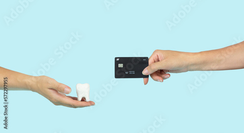 Concept to visualize value or price of work of doctor dentist. Cost of dental treatment. Hand pay for medical treatment and hold credit card.