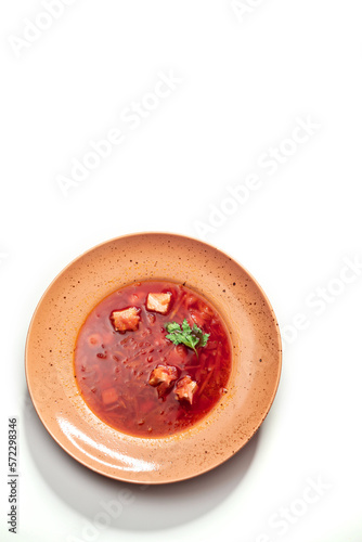 Ukrainian borscht in a plate on a white background, top view