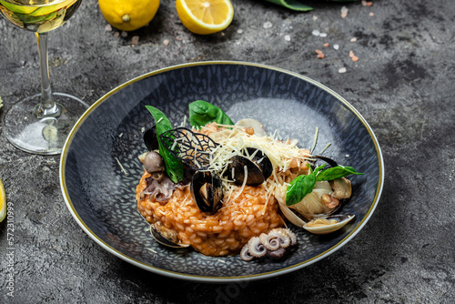 Italian risotto with shrimps, mussels, octopus, clams and glass of white wine, Restaurant menu, dieting, cookbook recipe top view