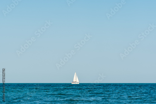 single white boat on the black sea