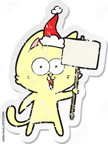 funny distressed sticker cartoon of a cat with sign wearing santa hat