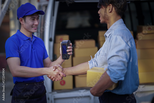 Deliver service. Man With Box in Car Outdoors Delivery Man in uniform holds parcel and phone car outdoors Delivery man taking parcels from The Delivery service