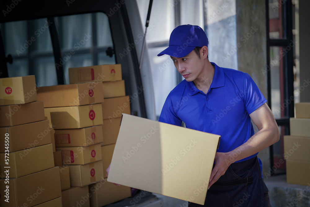Deliver service. Man With Box in Car Outdoors Delivery Man in uniform holds parcel and phone car outdoors Delivery man taking parcels from The Delivery service Deliver service. Man With Box in Car Outdoors Delivery Man in uniform holds parcel and phone car outdoors Delivery man taking parcels from The Delivery service
