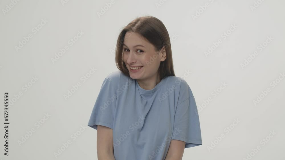 Video of a surprised brunette who covers her mouth with her hands. Shooting from the studio on a white background. Video of a surprised brunette who covers her mouth with her hands. Shooting from the studio on a white background.