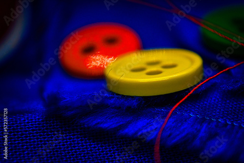 Buttons sitting on top of a piece of blue cloth.
