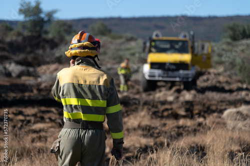 Un bombero forestal habla por teléfono mientras se dirige hacia el camión de bomberos. photo