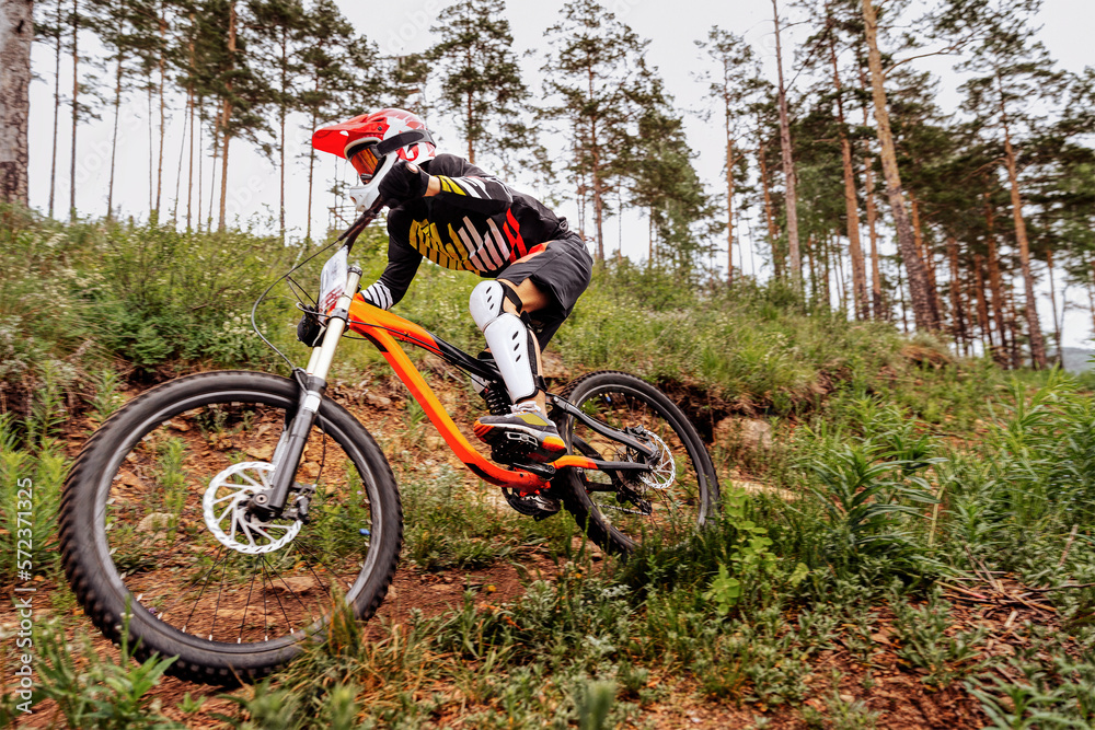 downhill mountain biker on forest trail. competition DH