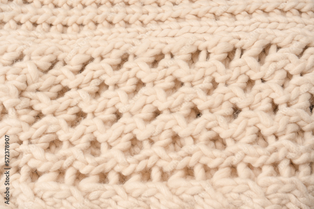 A fragment of beige knitted fabric, knitted from white sheep wool. A fragment of beige knitted fabric, knitted from white sheep wool.