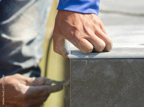 Worker is installing tiles on the floor