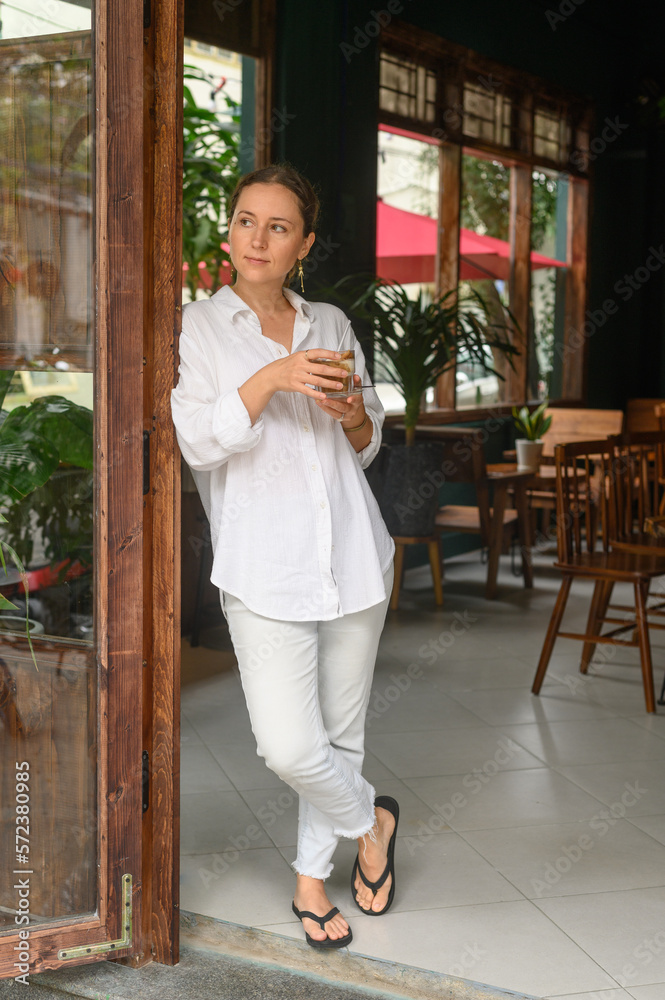 Pensive woman with coffee standing in cafe Pensive woman with coffee standing in cafe