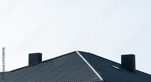 Black corrugated metal profile roof installed on a modern house. Modern construction